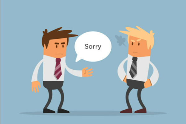 Hình ảnh hai nhân viên công sở đang giao tiếp với nhau, một người xin lỗi trong khi người kia tỏ thái độ không hài lòng. Hình ảnh minh họa tình huống xung đột và cách giải quyết bằng kỹ năng giao tiếp công sở